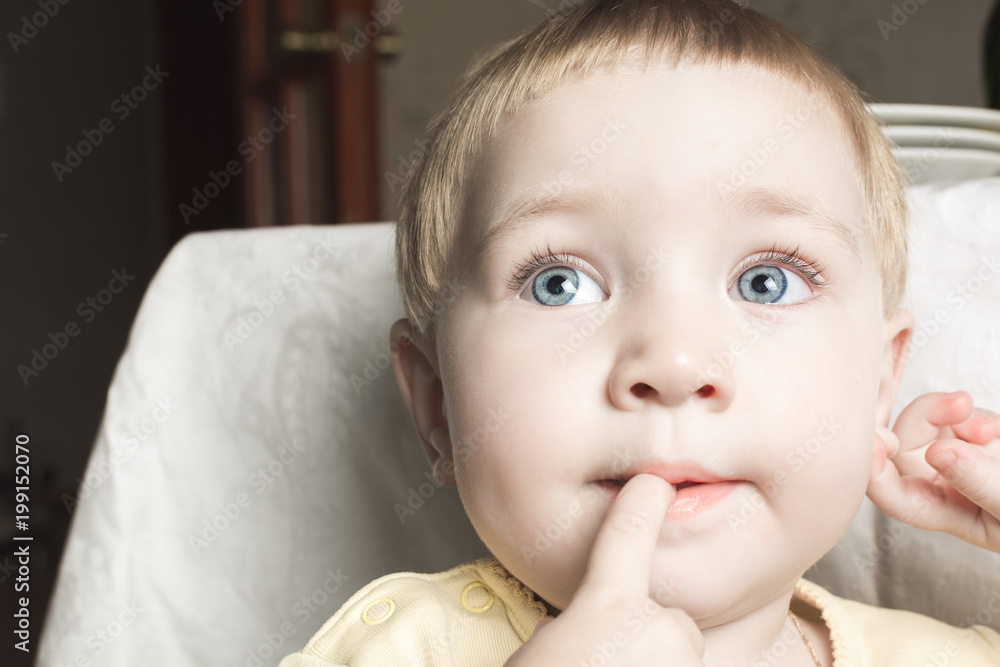 Beautiful child bites his fingers in his mouth Beautiful child bites his fingers in his mouth