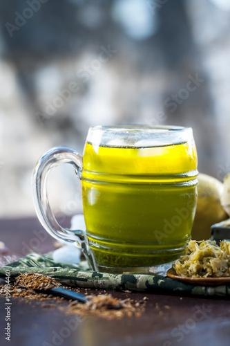 Close up of Indian and Asian famous mango juice AAM PANNA in a transparent glass with ice cubes and cumin powder ,sugar, and black salt in dark Gothic colors. photo