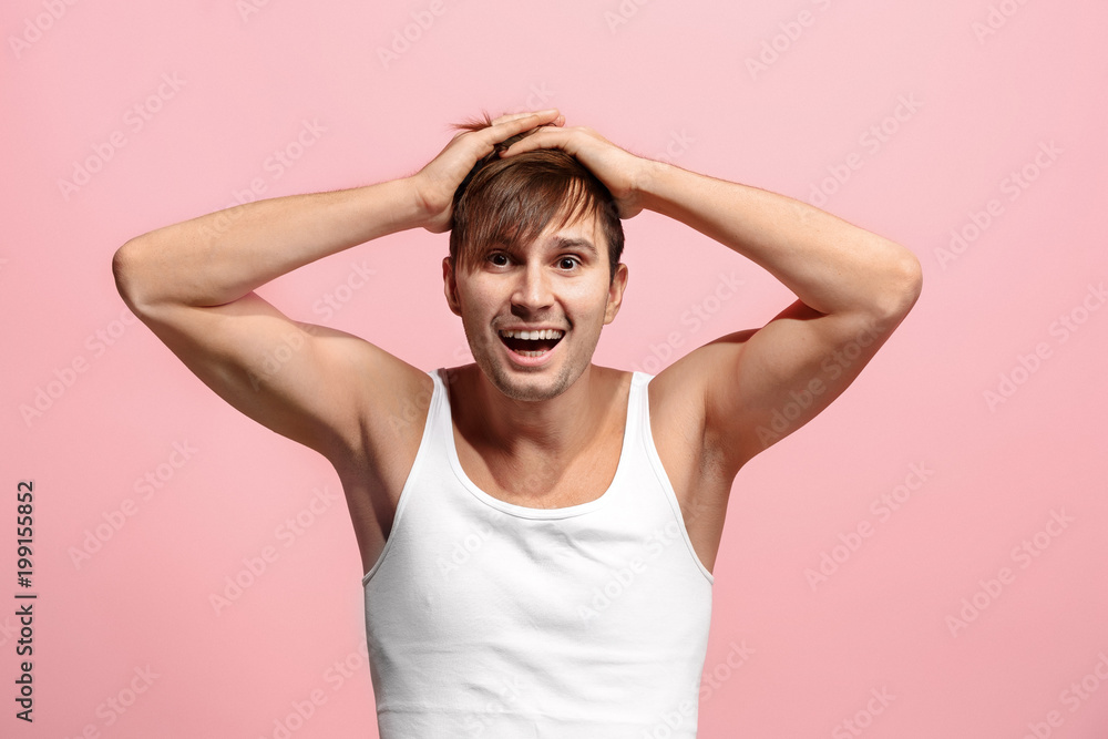 The happy man standing and smiling against pink background. The happy man standing and smiling against pink background.