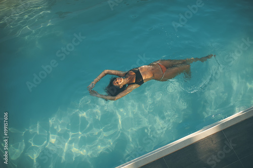 Young woman floating in the pool