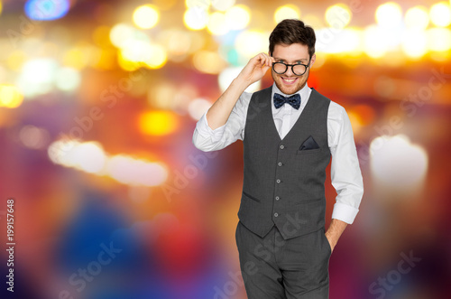 fashion, style and vintage concept - happy man in festive suit and eyeglasses over night city lights background