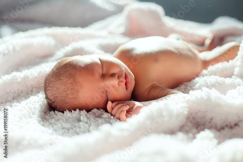 Newborn baby sleeping on white background in backlight