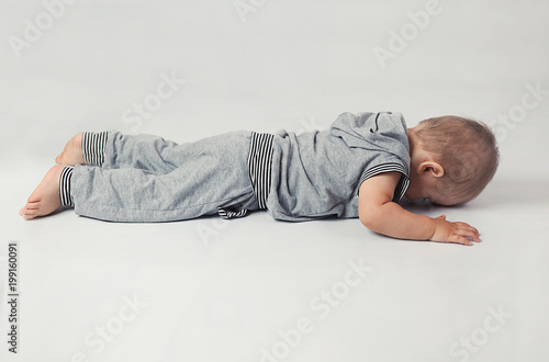 Little boy doing exercise in Studio on white background
