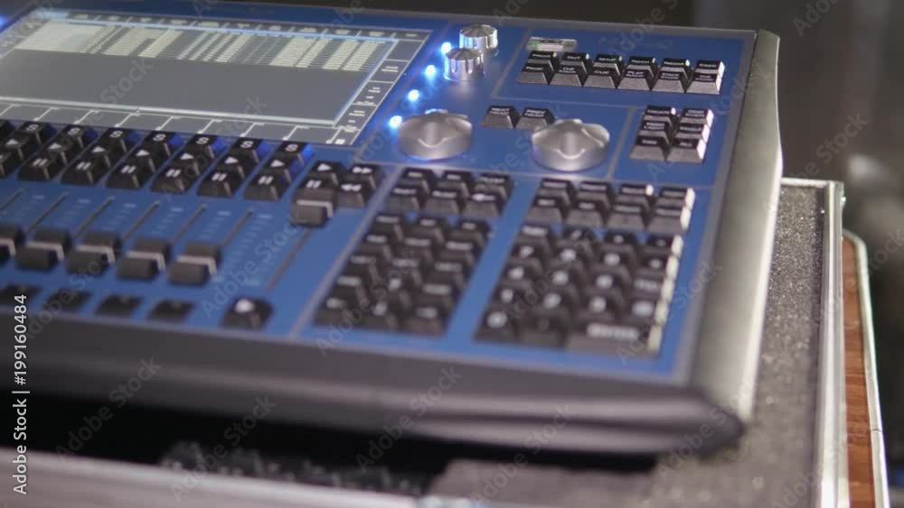 Close up pan across a media control console at an outdoor live event light show concert Close up pan across a media control console at an outdoor live event light show concert