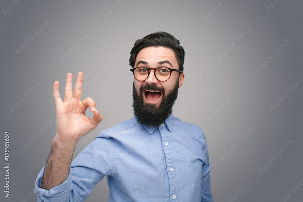 Man in glasses gesturing OK Man in glasses gesturing OK