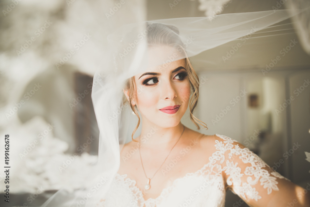 Gorgeous bride in robe posing and preparing for the wedding ceremony face in a room Gorgeous bride in robe posing and preparing for the wedding ceremony face in a room