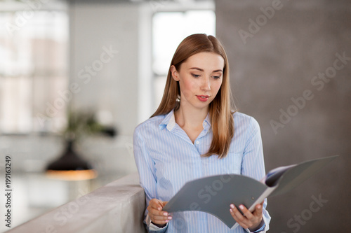 business, people and corporate concept - female office worker with folder