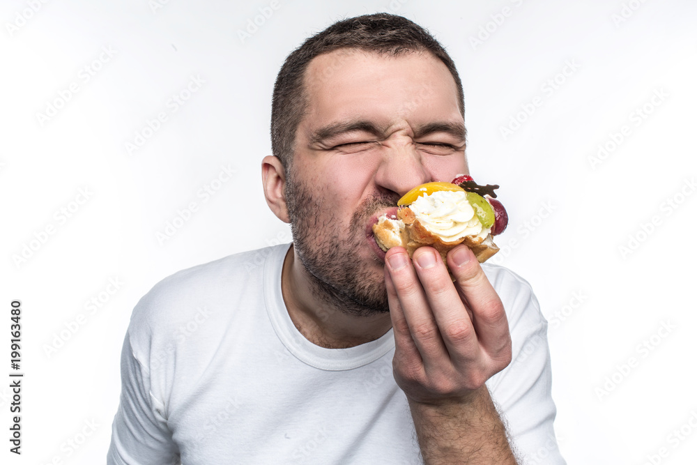 Closer shot of strang and weird man that likes to eat lots af unhealthy and sweet food. He is enjoying to eat this creamy dessert. Isolated on white background. Closer shot of strang and weird man that likes to eat lots af unhealthy and sweet food. He is enjoying to eat this creamy dessert. Isolated on white background.