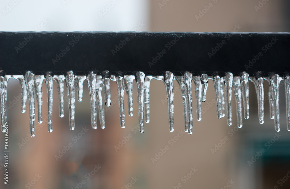Close Up of icicles hanging on iron row of balcony in house, Ice coated background. Close Up of icicles hanging on iron row of balcony in house, Ice coated background.