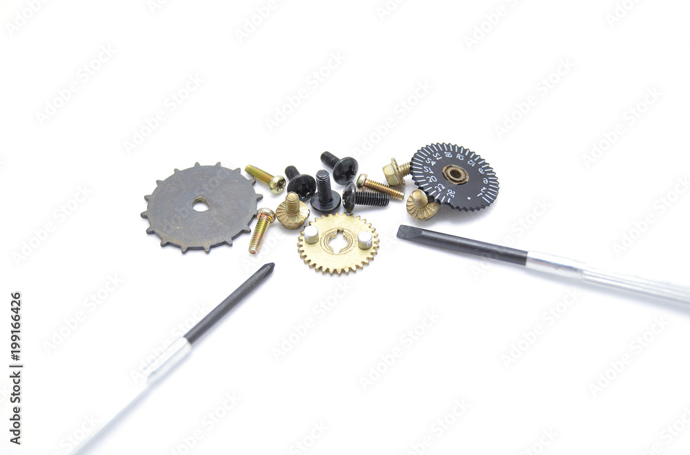 Gears, screws and screwdriver on white background closeup Gears, screws and screwdriver on white background closeup