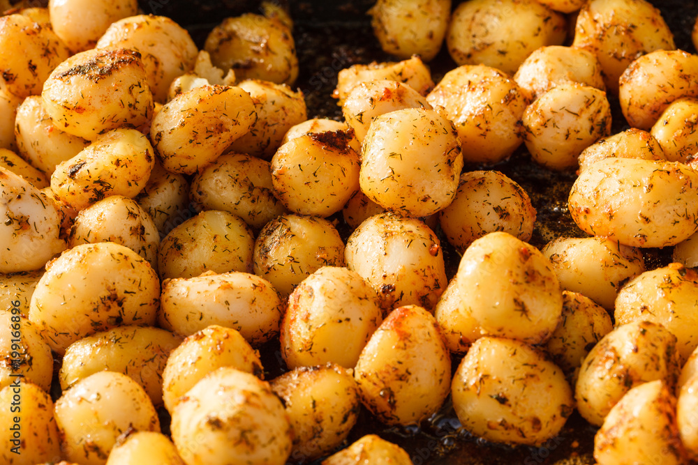 Backed young potatoes with spices in bowl Backed young potatoes with spices in bowl