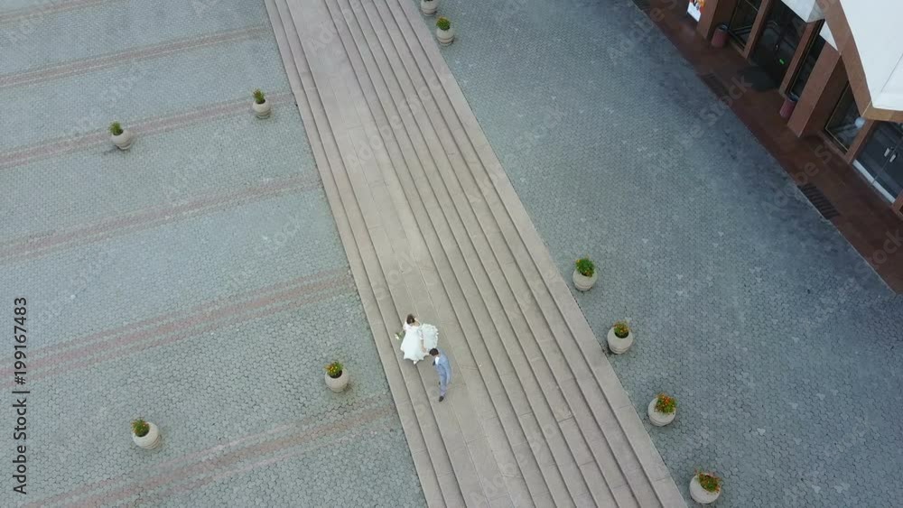 Aerial view. Just married couple walking in the city. Beautiful bridal couple Aerial view. Just married couple walking in the city. Beautiful bridal couple