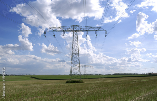 Power Lines: A 110 KV and a 220 KV high-voltage power line crossing over a stubblefield in Eastern Thuringia photo