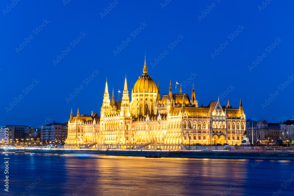 Famous Budapest parliament at the river Danube during blue hour from the side Famous Budapest parliament at the river Danube during blue hour from the side