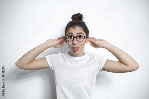 Funny positive girl fools around showing her tongue.