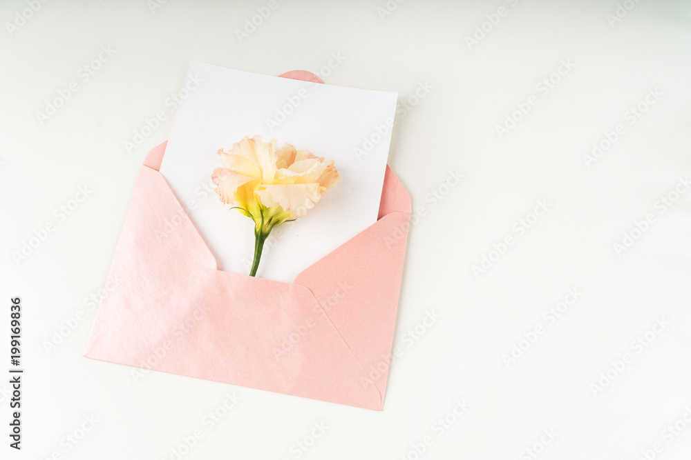 Minimal composition with a pink envelope, white blank card and eustoma flower on a white background. Mockup with envelope and blank card. Flat lay. Top view. Minimal composition with a pink envelope, white blank card and eustoma flower on a white background. Mockup with envelope and blank card. Flat lay. Top view.
