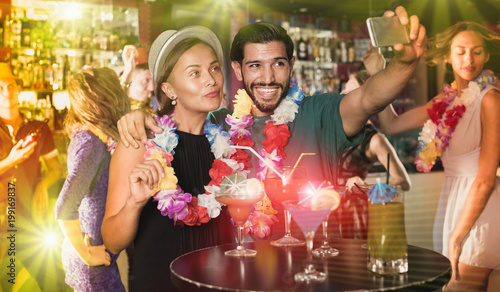 Couple making selfie with cocktails