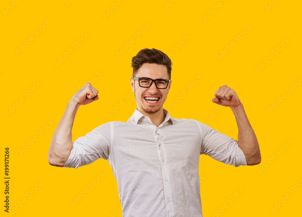 Young man in glasses holding hands up celebrating success Young man in glasses holding hands up celebrating success