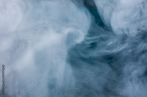 Fluffy Puffs of Smoke and Fog on Blue Background
