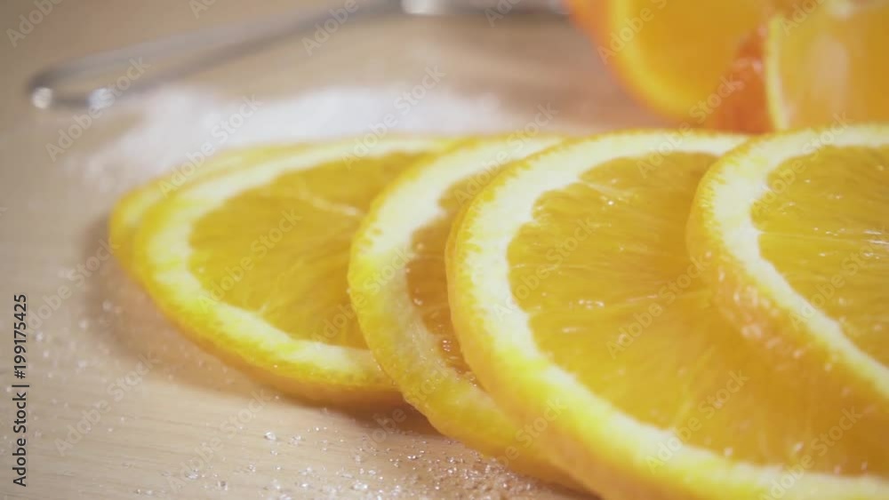 Movement of the camera along the orange slices with scattered sugar on the table close-up slow motion Movement of the camera along the orange slices with scattered sugar on the table close-up slow motion