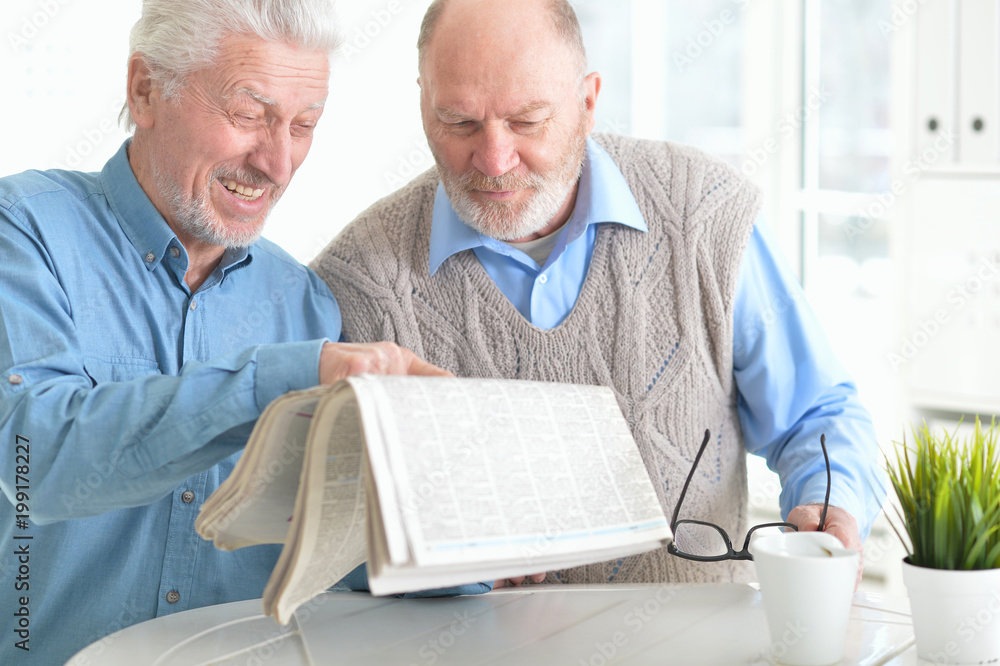 Two senior men reading newspaper Two senior men reading newspaper