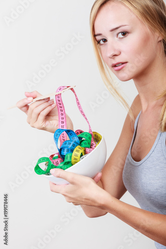 Diet. Girl with colorful measuring tapes in bowl