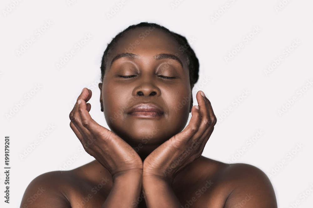 Young African woman with perfect skin against a white background Young African woman with perfect skin against a white background
