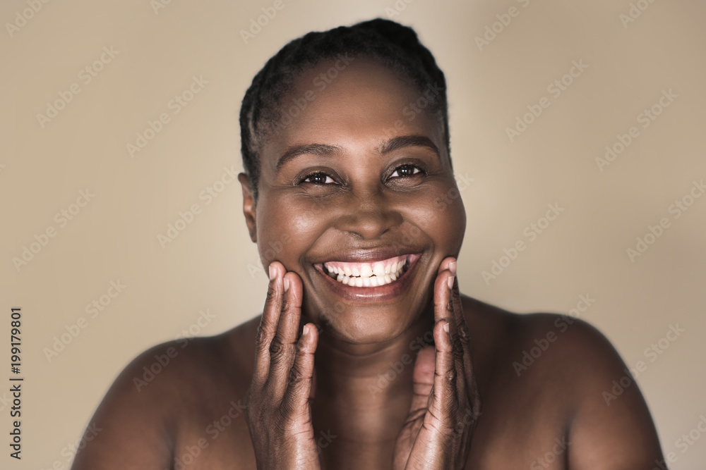 Young African woman smiling and touching her perfect complexion Young African woman smiling and touching her perfect complexion