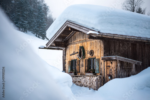 old traditional wooden cabin lodge shack in bavarian alps with lots of snow in winter photo