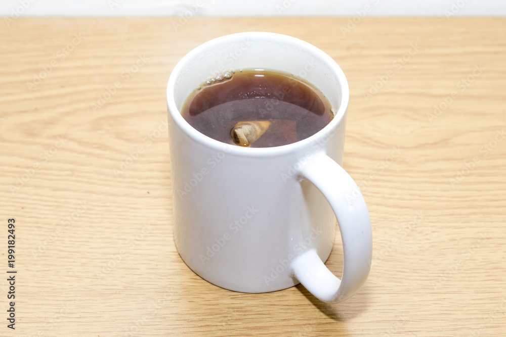 Obraz premium Cup of black tea with tea bag