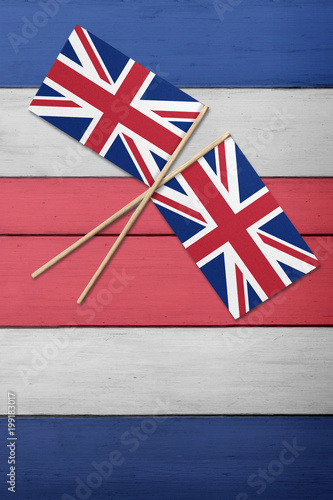 Two United Kingdom flags on a red white and blue painted wood background