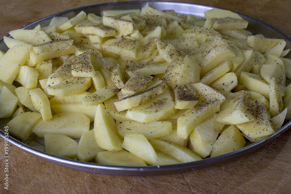 Raw potatoes sliced for cooking French fries in a rustic manner. Raw potatoes sliced for cooking French fries in a rustic manner.