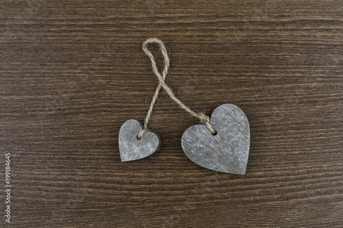 Hearts on a wooden background. Hearts connected with a rope.