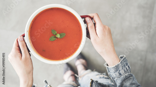 Obraz na plátně Woman holding tomato soup pot high angle view