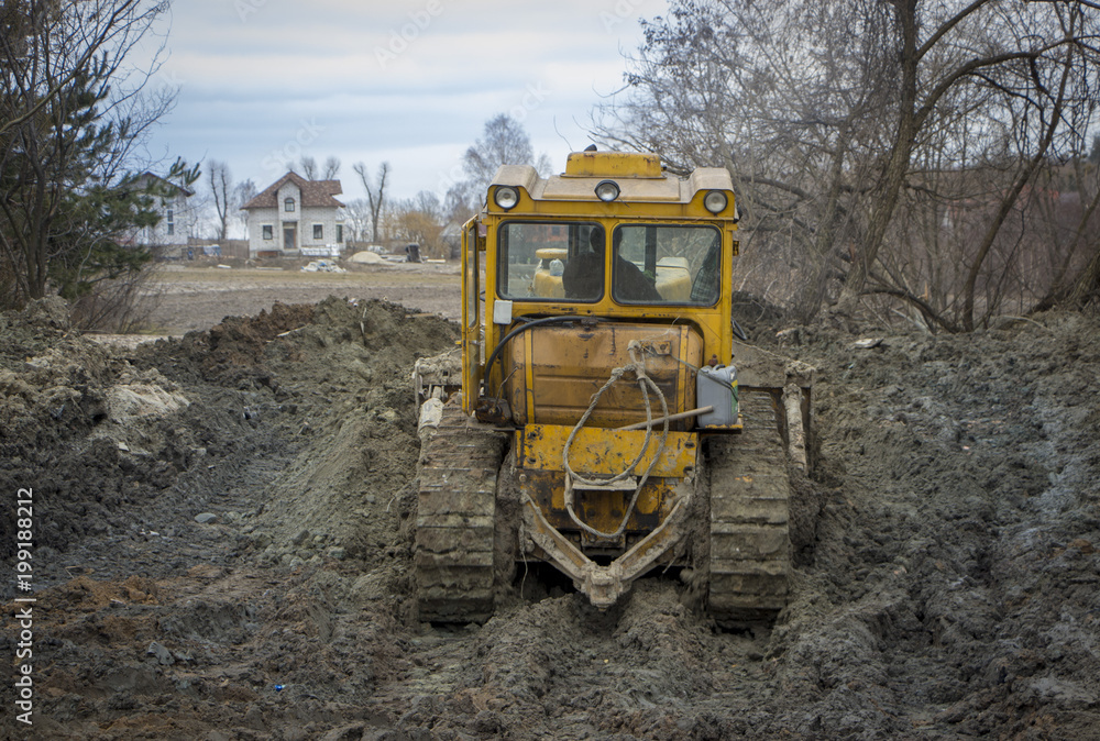 A large bulldozer digs a reclamation channel