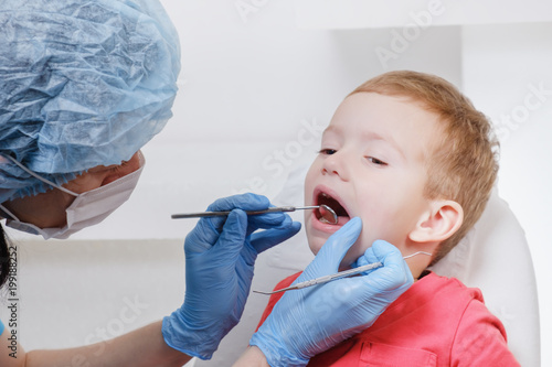 Dentist examination of child patient teeth using a mirror of instrument Caries, tooth damage, illness.