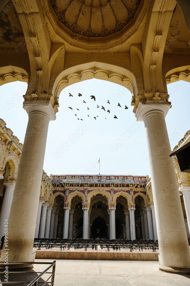 Indian architecture Thirumalai Nayakkar Mahal palace with flying birds through arch in Madurai