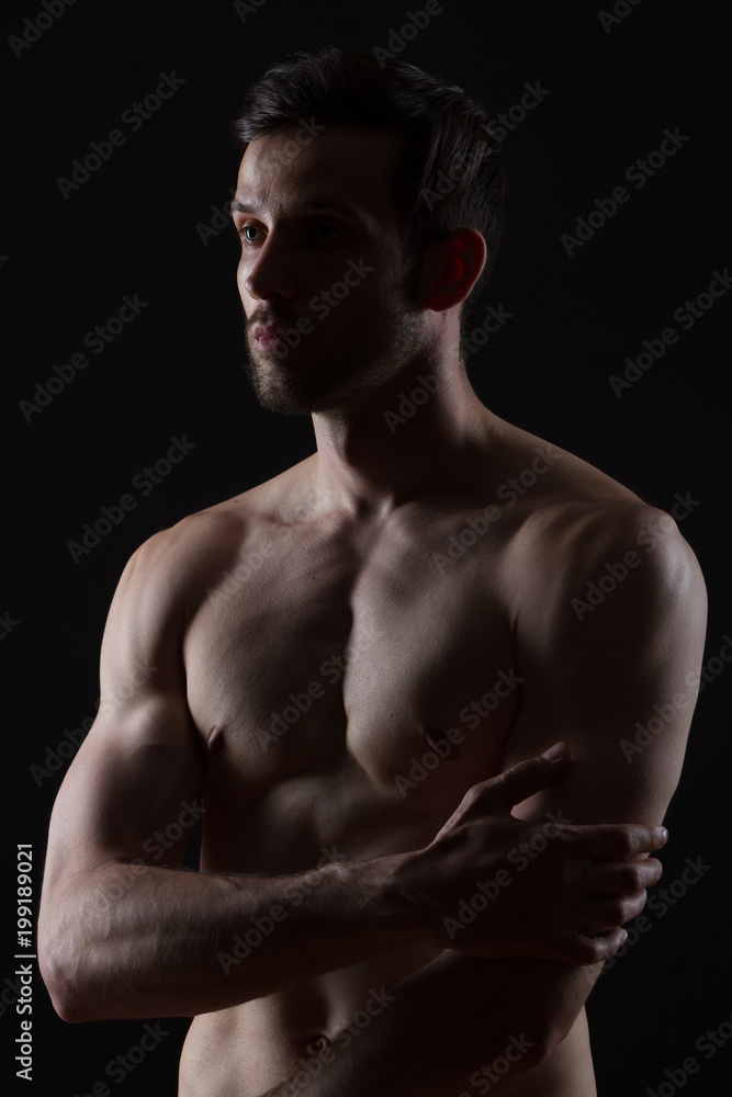 Fototapeta premium young man with muscles on black background