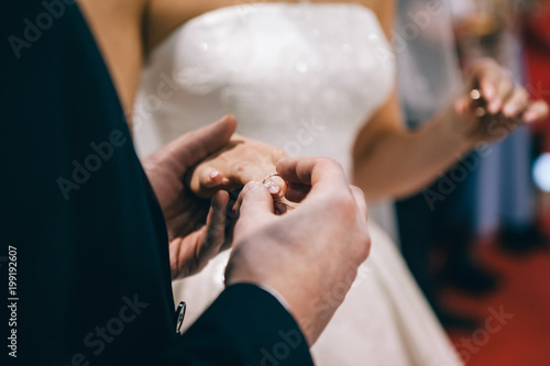 wedding couple pulls each other rings to the finger