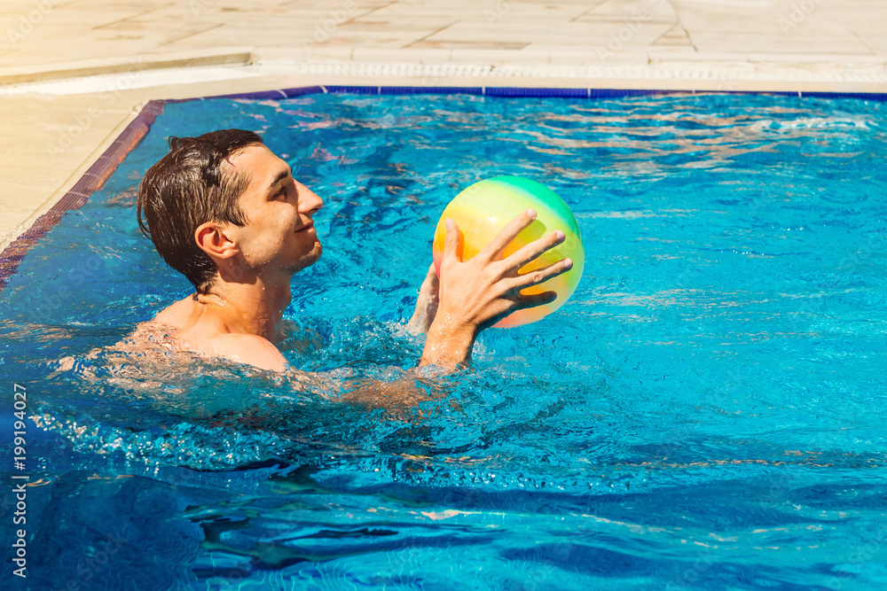 Young man playing water polo in swimming pool. Water sports. Healthy lifestyle concept. Summer activity