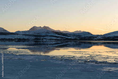 A Norwegian fjord near Troms   covered with ice at sunset  Troms    Norway