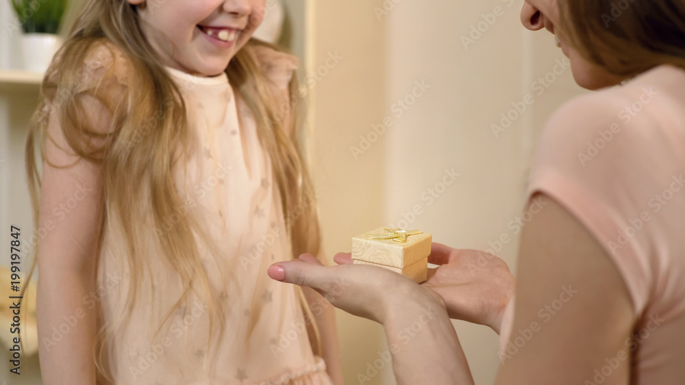Happy woman receiving mothers day gift from little daughter, family values Happy woman receiving mothers day gift from little daughter, family values