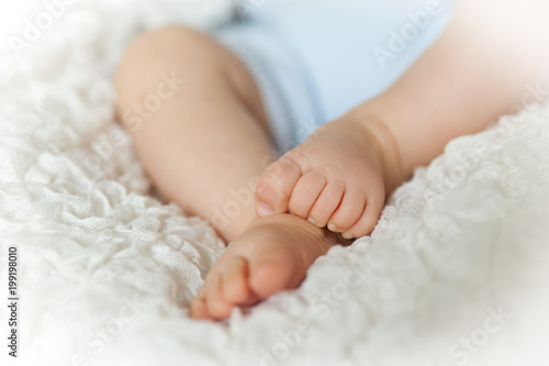 Cute children's legs on white blanket