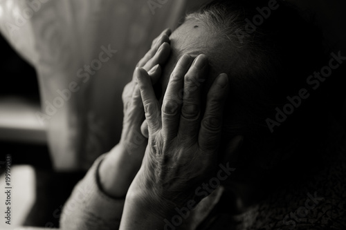 An elderly woman sitting at the table in a depressed state,black and white photo