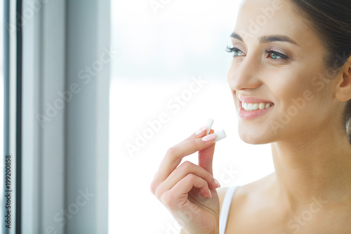 Beautiful young woman eating chewing gum  smiling