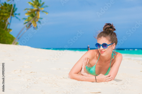 pretty woman in bikini relaxing at white sand beach