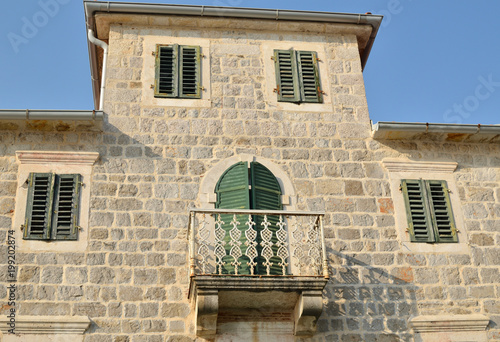 Villa built of stones with two floors and a balcony with iron fence
