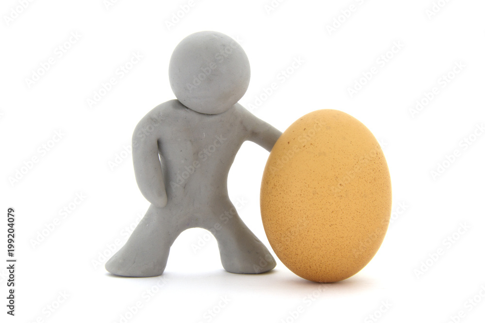 Gray plasticine character and single fresh chicken egg. Isolated over white background Gray plasticine character and single fresh chicken egg. Isolated over white background