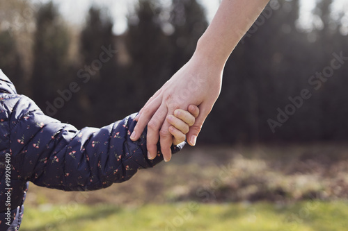 Mother holding her daughter hand