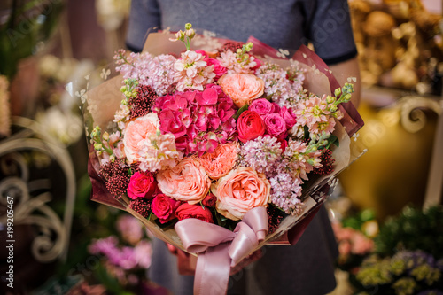 Girl holding a beautiful bouquet of pink and peach flowers
